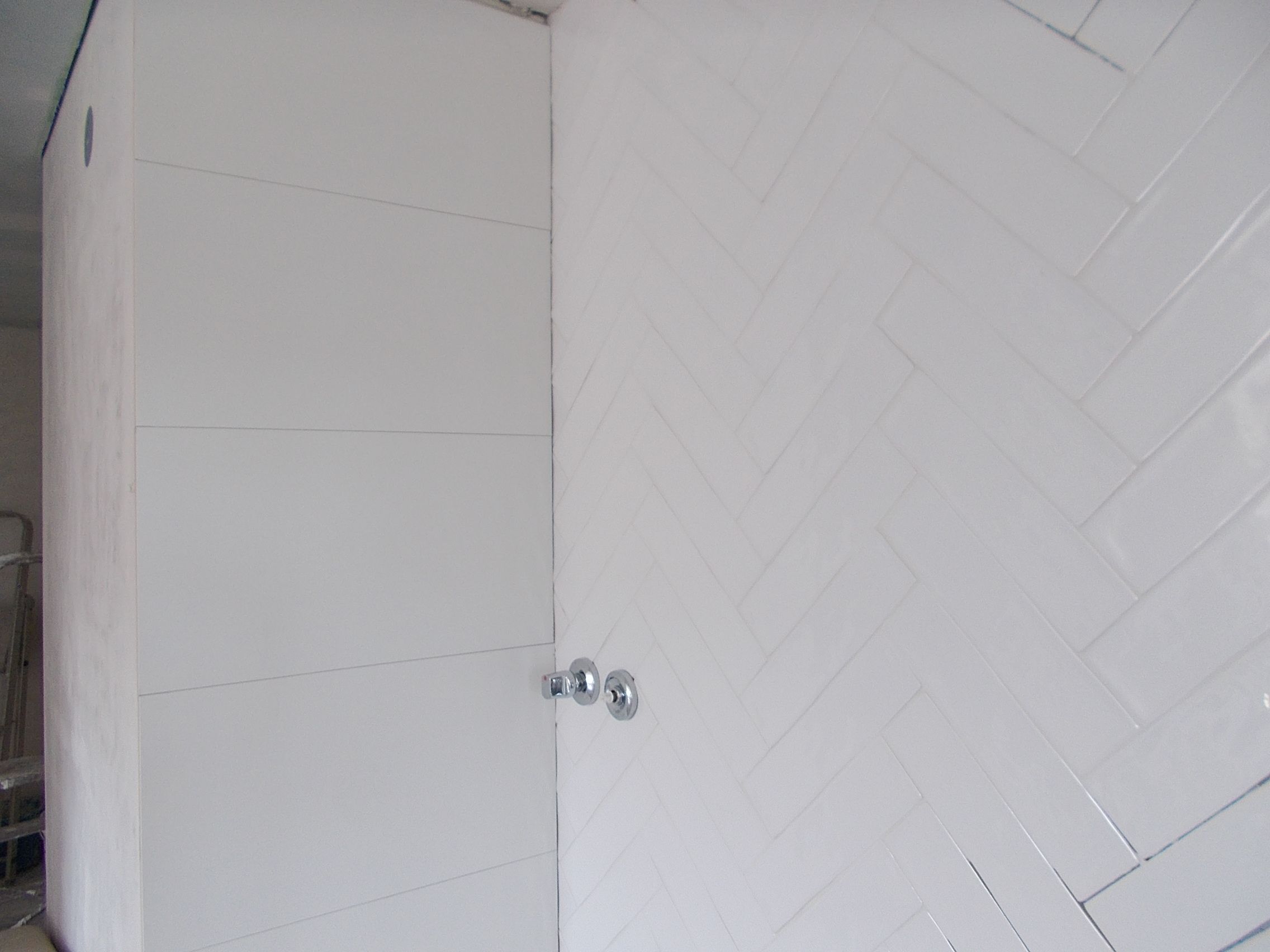 Fotografia de uma parede em azulejo branco